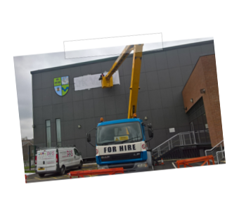 Cherry Picker being used to apply a logo on the side of a building